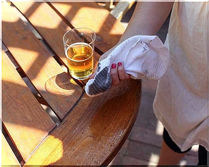 Person cleaning a table with beer