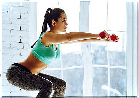 Woman doing squats with dumbbells