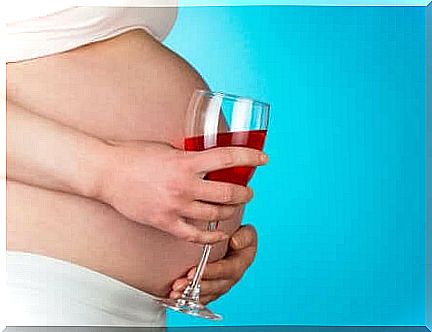 Pregnant woman with wine shows habits that should be avoided during pregnancy