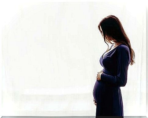 Pregnant woman in front of white wall