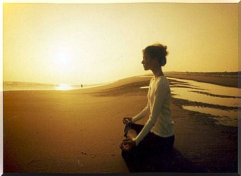 Woman meditating on a beach