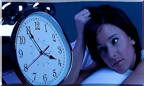 Woman looking at alarm clock at night