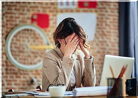 Woman sitting in front of computer with headache