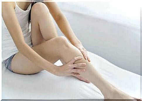 A woman massages swollen legs