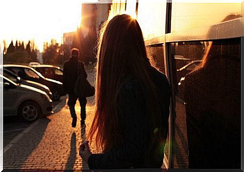 Young woman standing outside looking at the sun