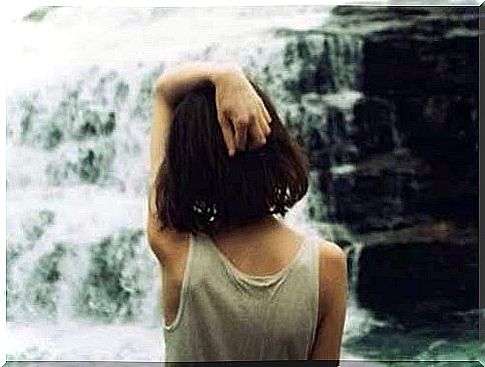 Girl standing in front of a waterfall