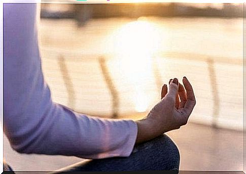 A woman meditates by the sea.